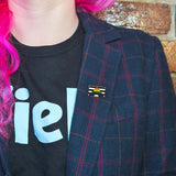 A straight ally pin on the lapel of a woman